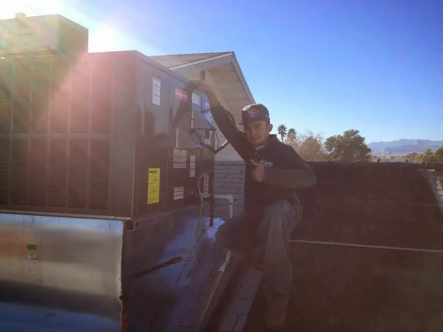 HVAC technician performing AC Tune-Up on a rooftop unit in Kahului
